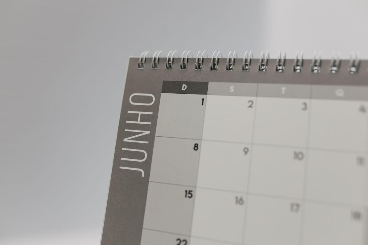 Close-up of a spiral-bound calendar open to the month of June showing a date grid